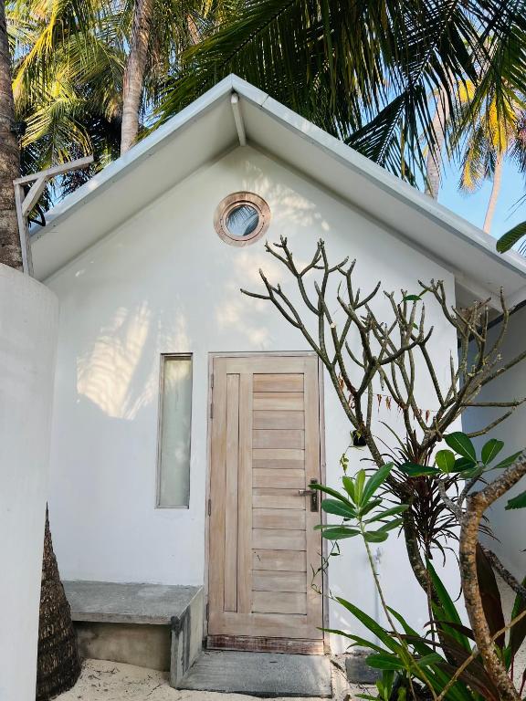 a small white building with a door and a window at 101 Sosi in Kudafari