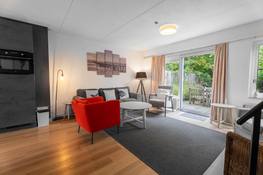 a living room with a red couch and a table at Spaanse Galeien 16 in Retranchement