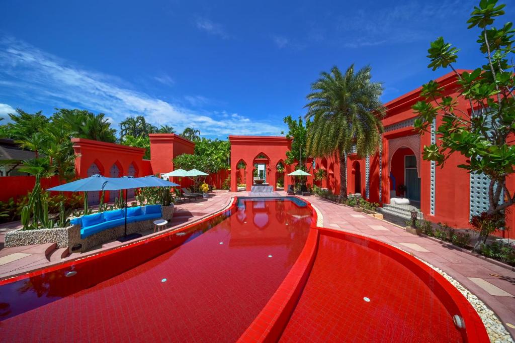 a red pool in front of a red building at The Kiri Villas Resort in Thalang