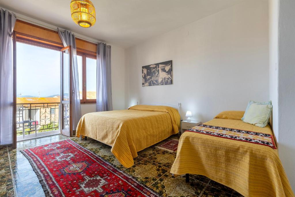 two beds in a room with a window at The Domus vicino ad Alghero in Olmedo