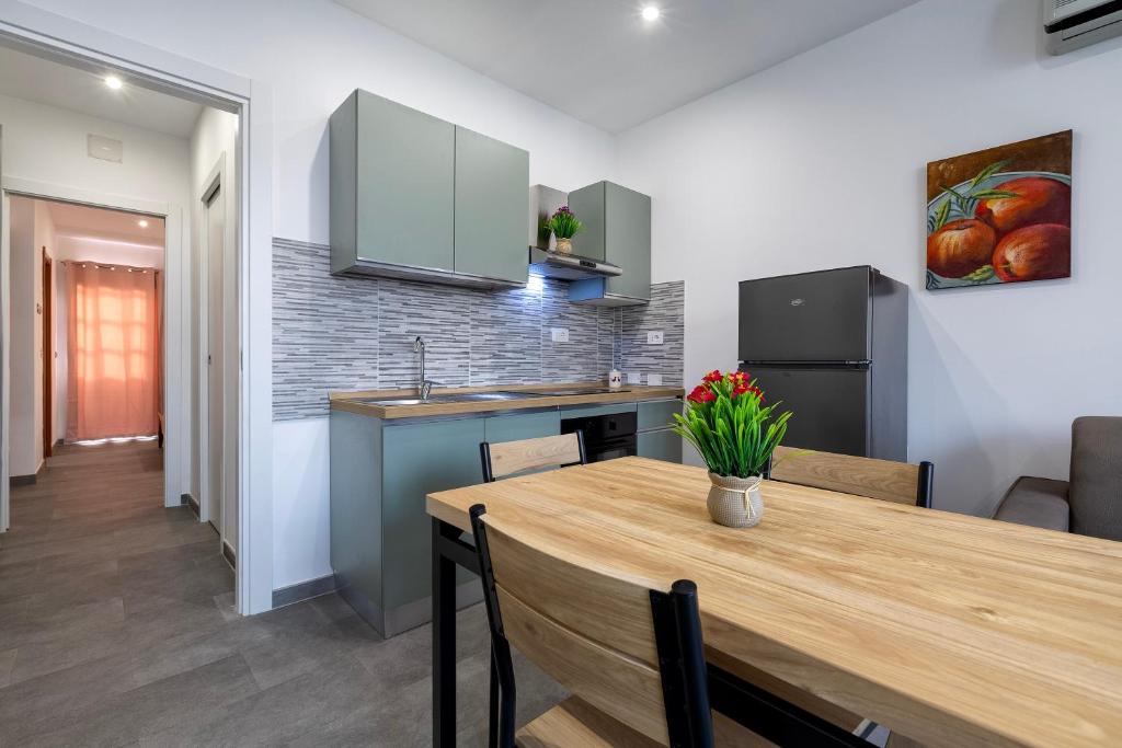 a kitchen and dining room with a wooden table at Emmeci House in Alghero