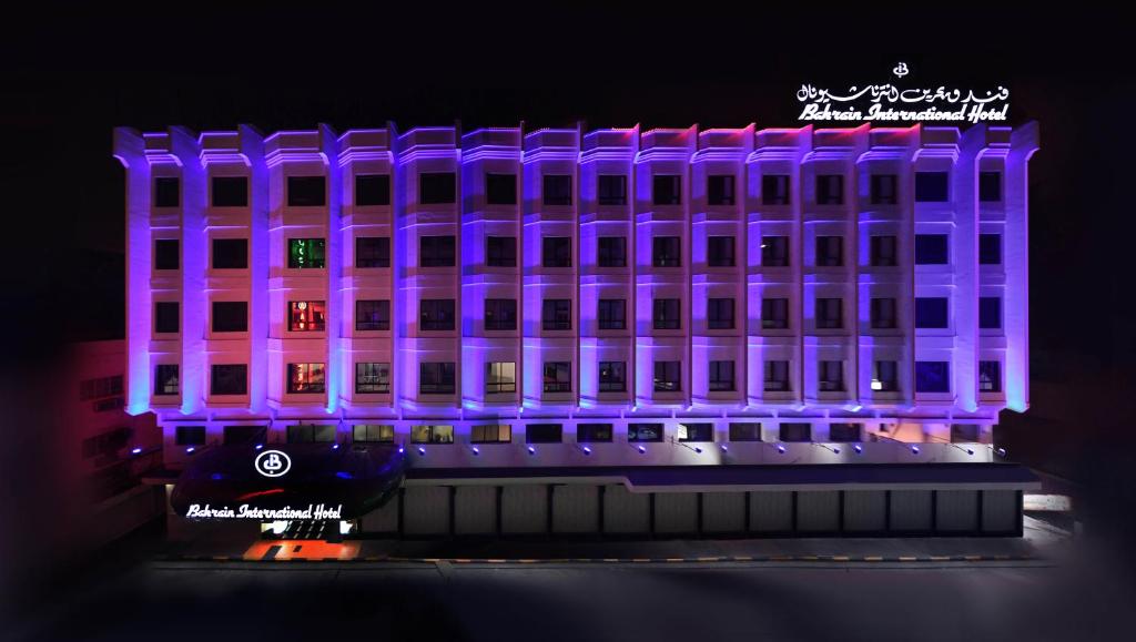 a building is lit up with purple lights at Bahrain International Hotel in Manama