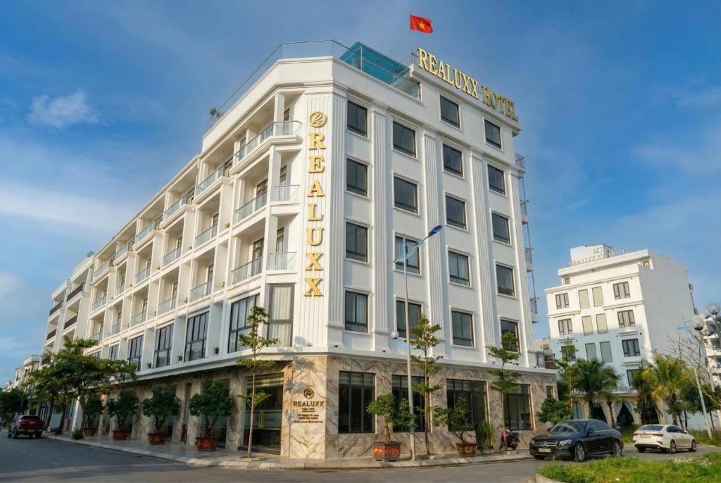 ein weißes Gebäude mit einem Hotelschild darauf in der Unterkunft Realux Hotel FLC Sam Son in Sầm Sơn