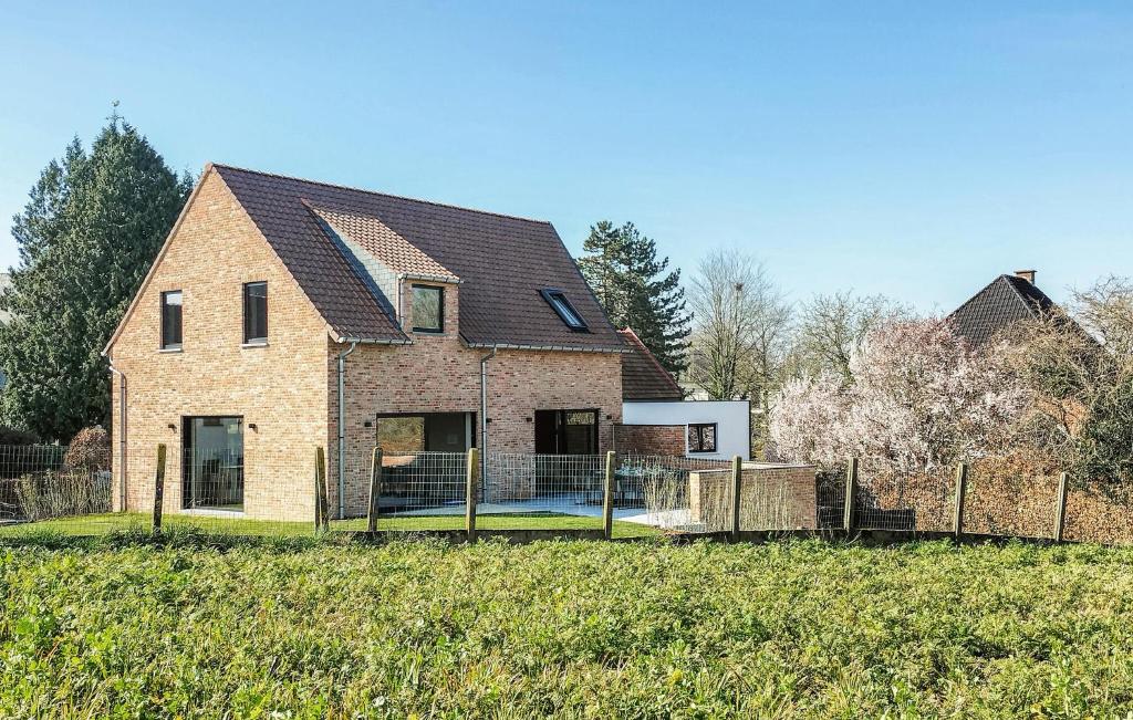 a brick house with a fence in a field at 5 Bedroom Beautiful Home In Oudenaarde in Oudenaarde