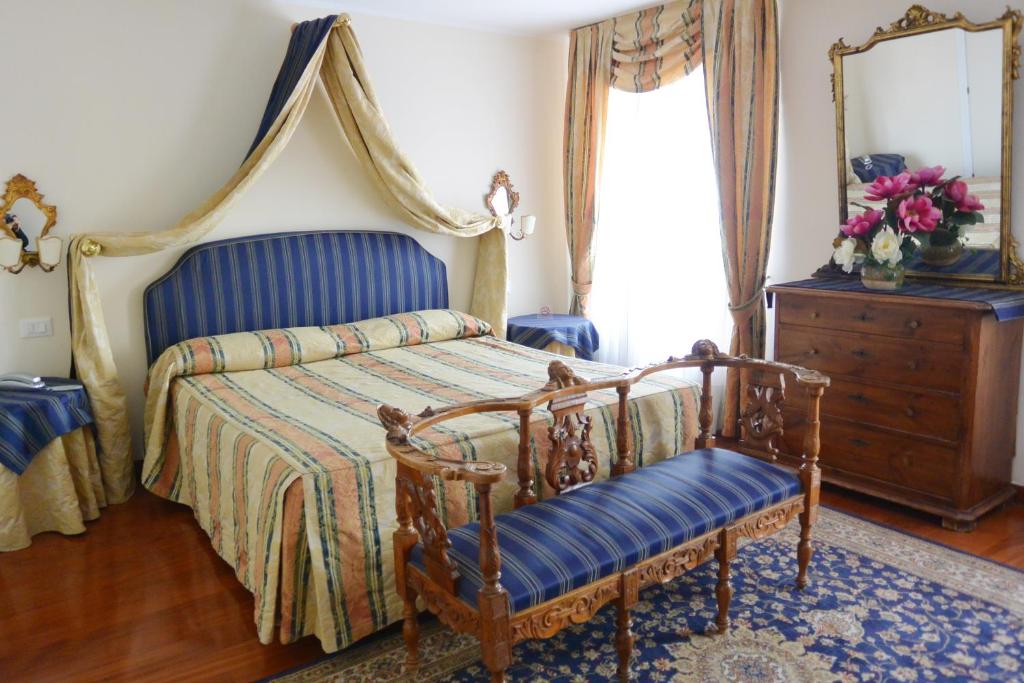 a bedroom with a bed and a dresser and a mirror at Hotel San Zulian in Venice