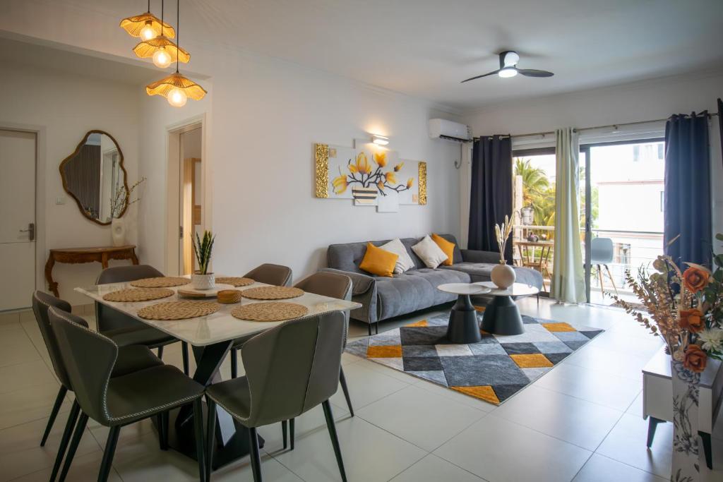 a living room with a table and a couch at Tropical Escape Flic en Flac in Flic-en-Flac
