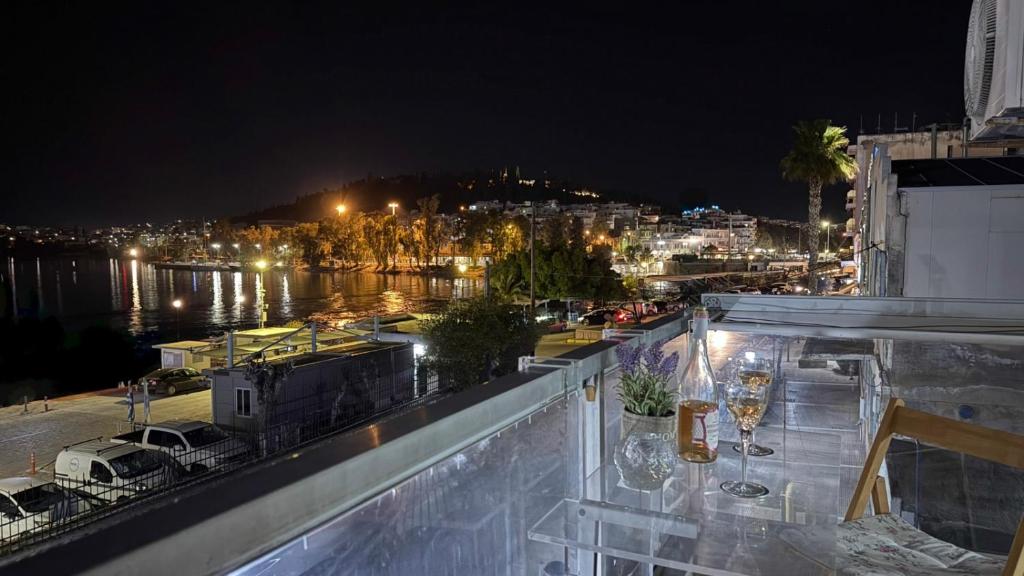 a view of a city at night with wine glasses at Seaside Apartment with a great view in Chalkida in Chalkida