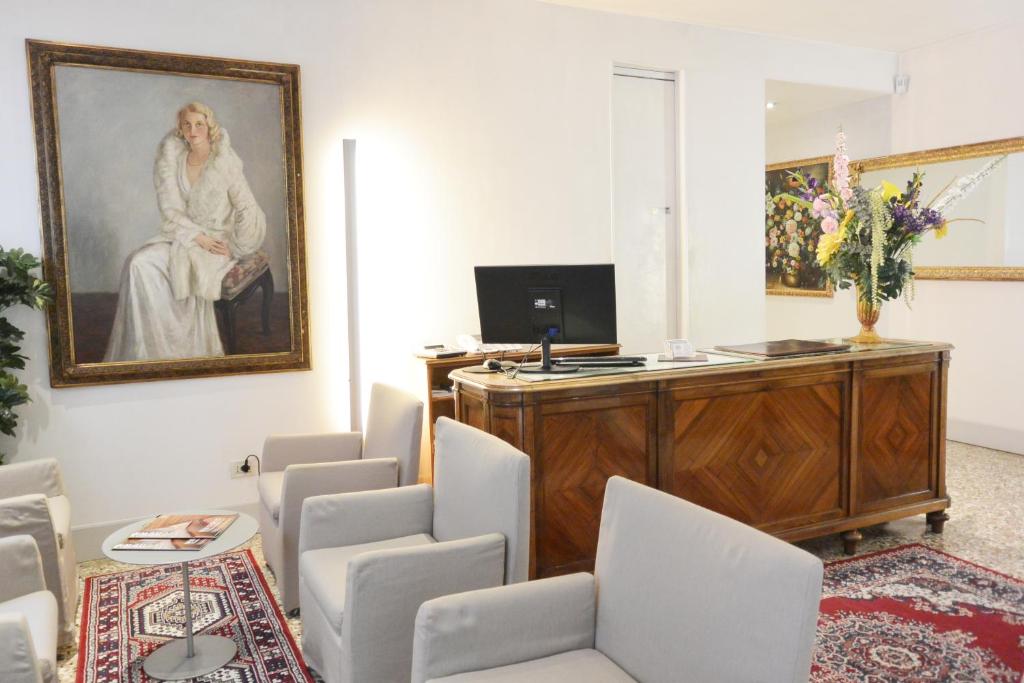 a room with chairs and a picture of a woman at Hotel San Zulian in Venice