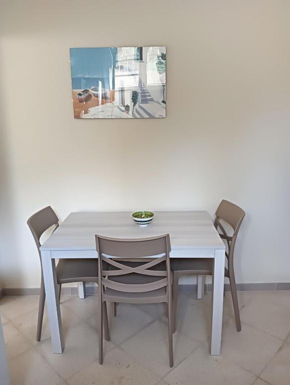 a white table with two chairs and a bowl on it at Cefalù Station House in Cefalù