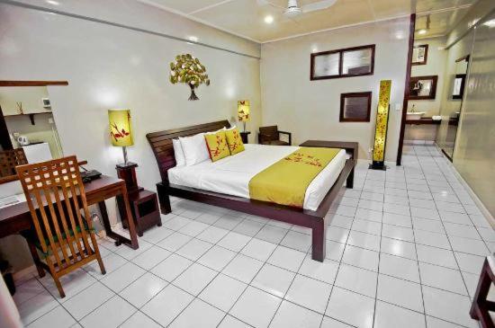 a bedroom with a bed and a desk and a bed sidx sidx sidx at Raintree Lodge in Port Moresby