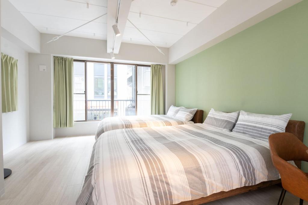 a bedroom with two beds and a large window at Evergreen hotel yotsuya in Tokyo