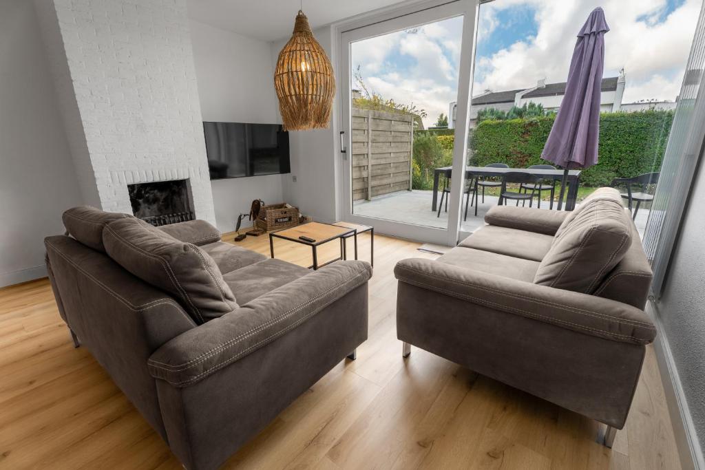 a living room with two couches and a television at Heggerank 5a in Nieuwvliet