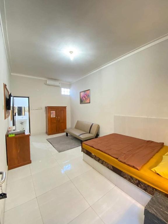 a bedroom with a bed and a couch in it at Baga Guesthouse in Kanggraksan