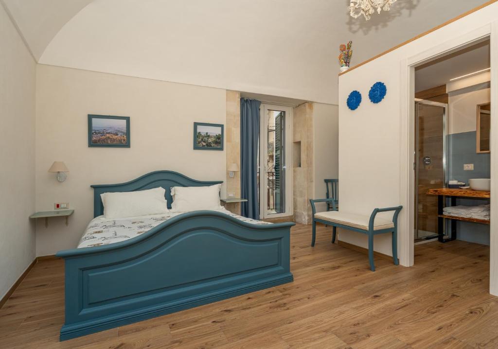a bedroom with a blue bed and a chair at Terrazza Campailla in Modica