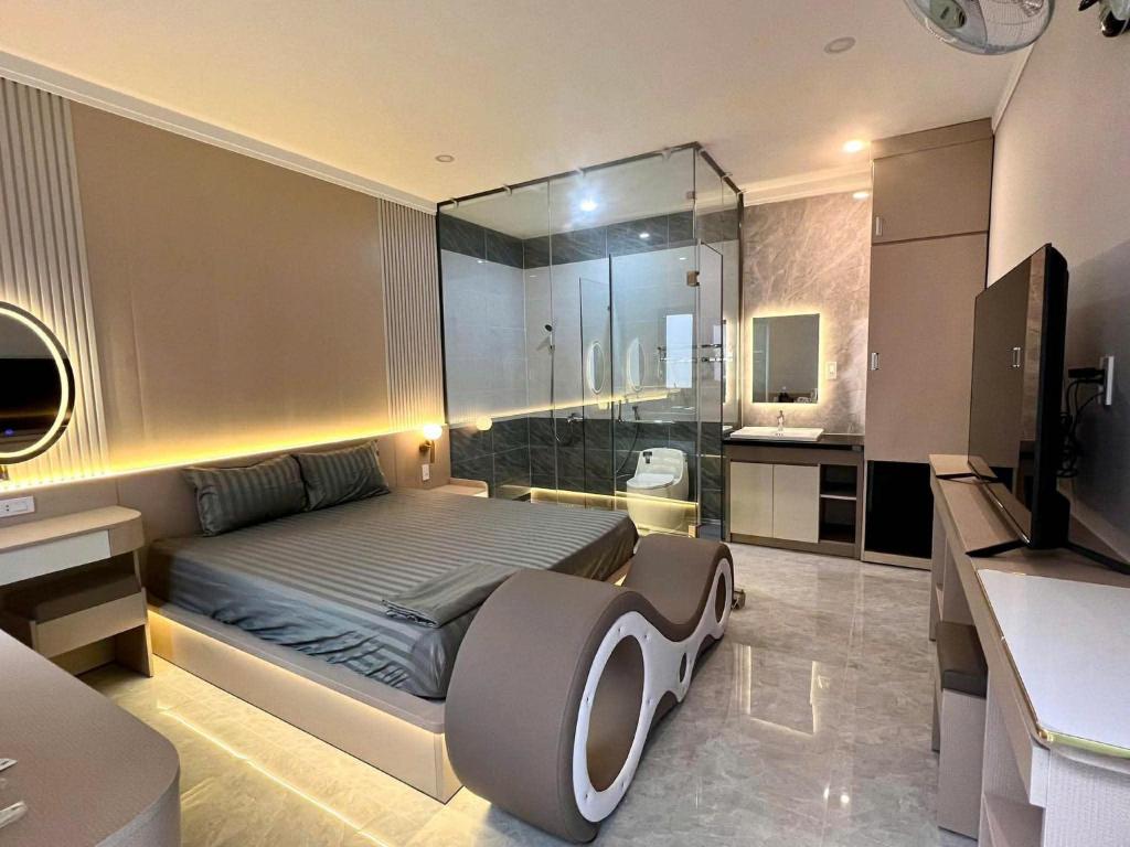 a bedroom with a bed and a glass shower at Hưng Phát Hotel 2 - Gadren in Phú Lợi