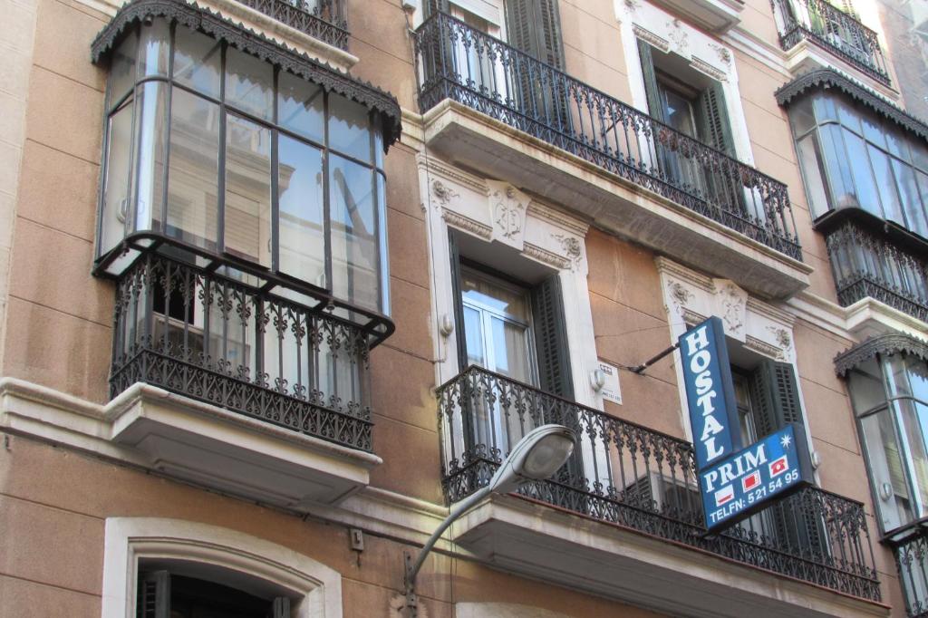 a building with balconies and a street sign on it at Hostal Prim in Madrid