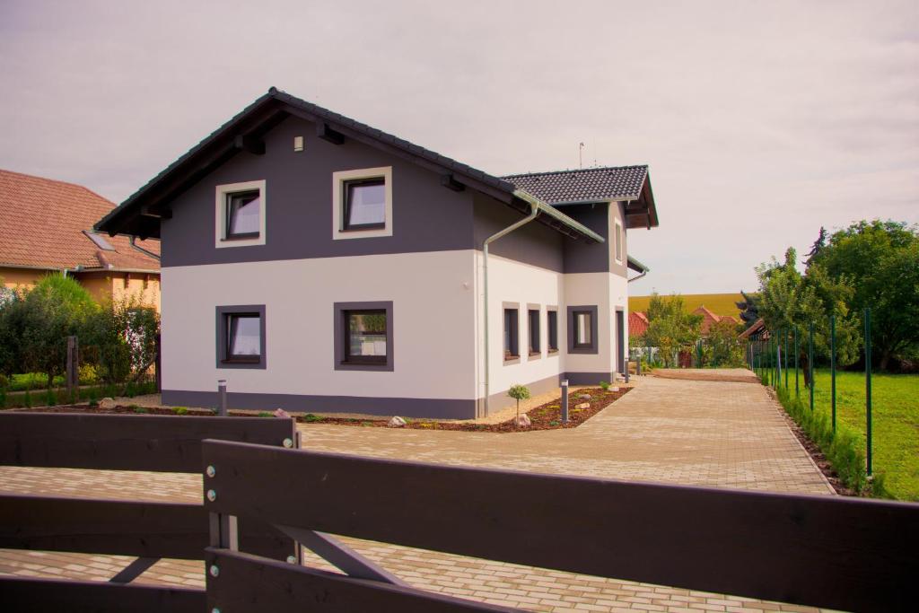 una casa blanca con techo negro en Apartmány Podhájska, en Podhájska