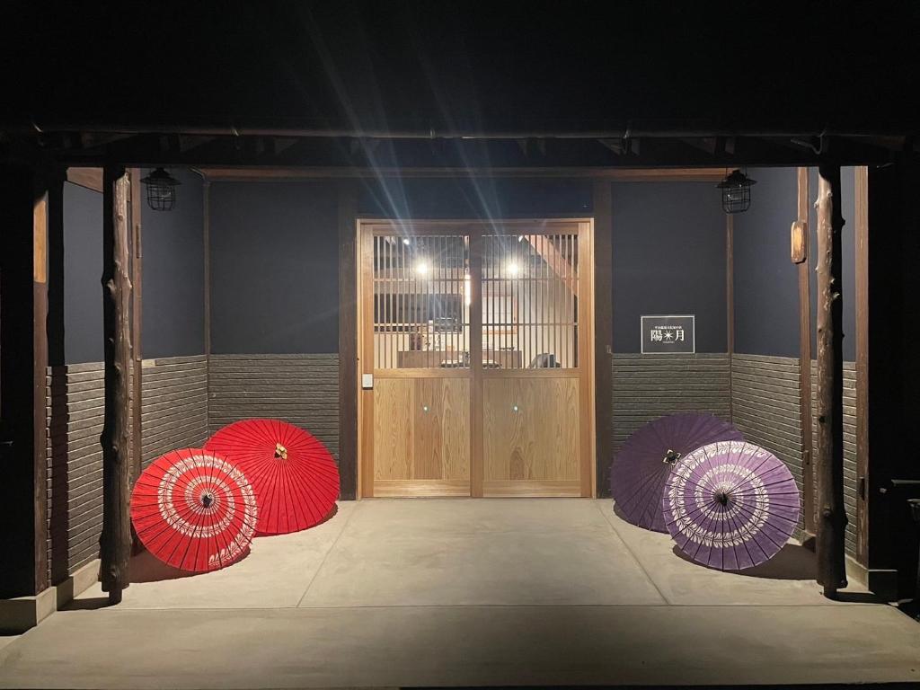 a room with three umbrellas in front of a door at 陽月 Yo-Getsu in Yamaga