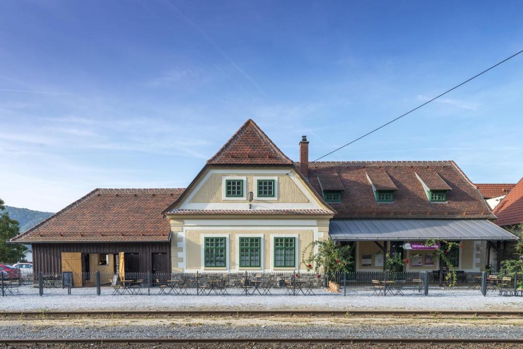 a building with a train station next to a train track at Railway cottage in Dürnstein in Dürnstein