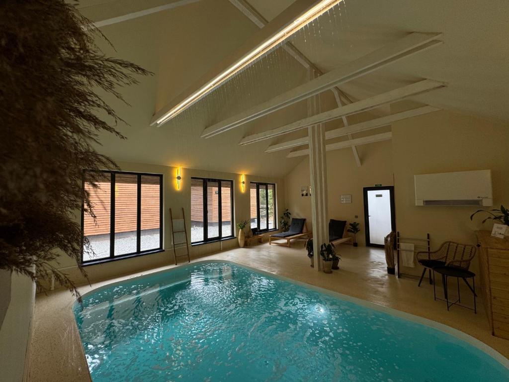 a large swimming pool in a room with at Apusenity Resort I Piscină Interioară & Cabane în Natură in Cluj-Napoca