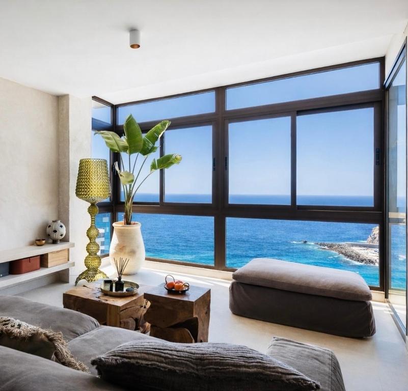 a living room with a large window overlooking the ocean at I Boho Sun Oceanfront Apartment in Icod de los Vinos