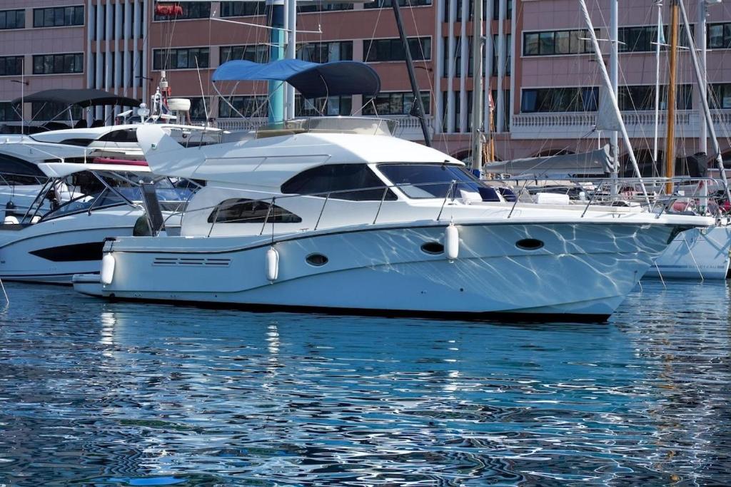 a white boat is docked in the water at Yacht Experience in Monaco Harbour in Monte Carlo
