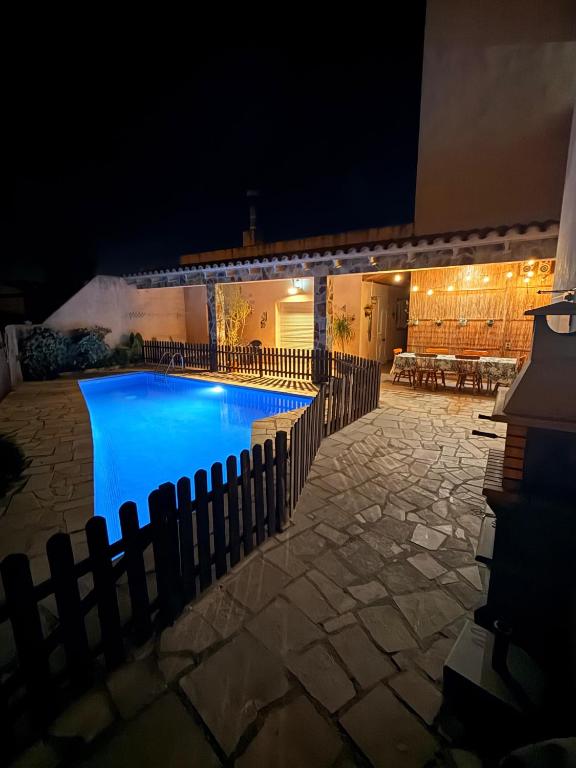 a swimming pool at night with a fence around it at Can Pantoni piscina privada in Deltebre
