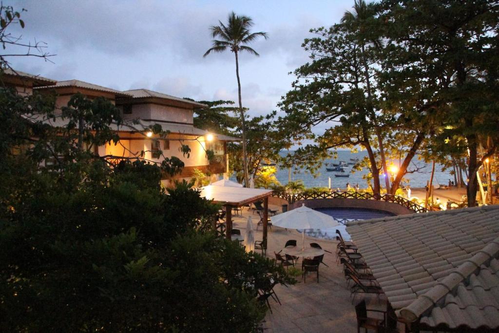 a resort with a table and chairs at night at Duplex na Praia do Forte de frente para o mar! in Praia do Forte