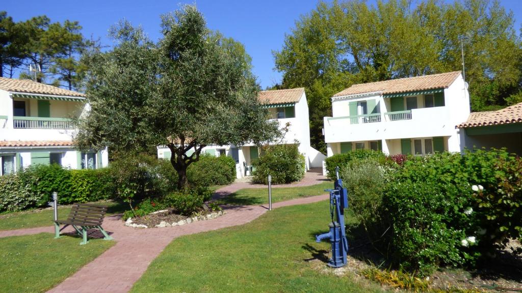 une rangée de maisons avec un banc dans une cour dans l'établissement Le Parasol, à Ars-en-Ré