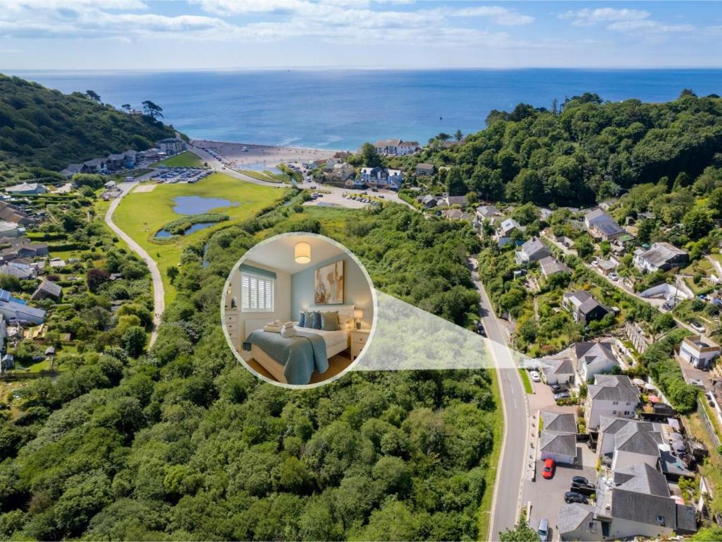 an aerial view of a house with the ocean in the background at 4 Bed in Torpoint oc-89135 in Sheviock