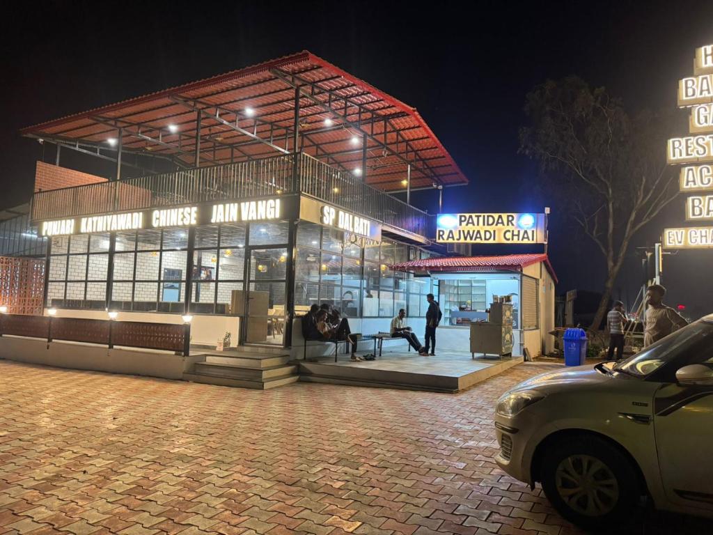 a man standing in front of a building at night at Hotel Bandhan in Himatnagar