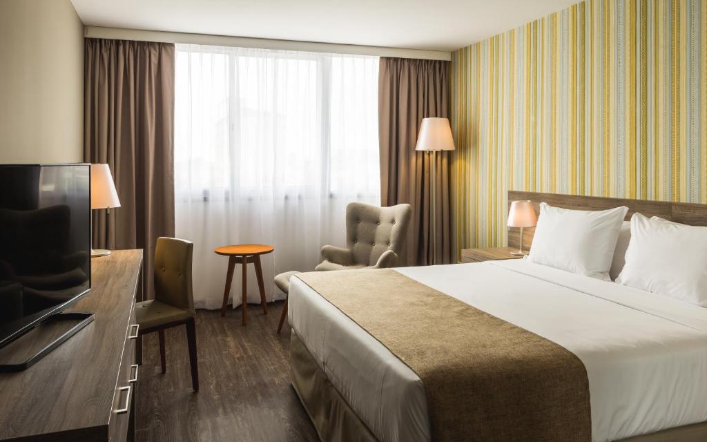 een hotelkamer met een bed en een televisie bij Frontier Hotel Rivera in Rivera
