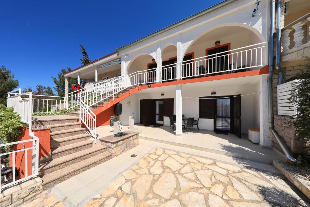 a large white building with stairs and a balcony at Hibis, No 2 in Starigrad