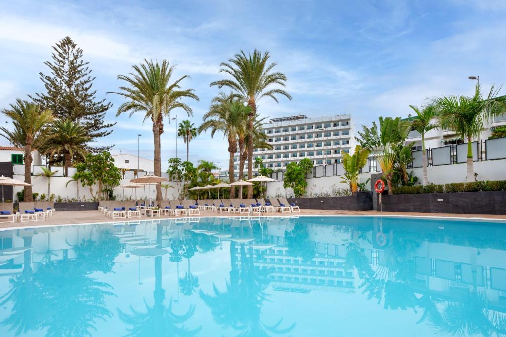 a large swimming pool with palm trees and a hotel at BLUESEA Marieta & Spa in Playa del Ingles