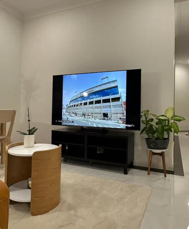 a living room with a large flat screen tv at Modern Suite Near Adelaide CBD in Woodville