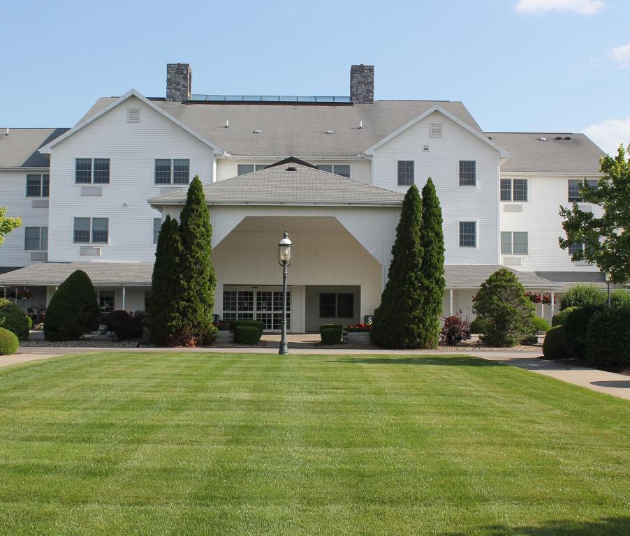 a large white house with a green lawn at Farmstead Inn and Conference Center in Shipshewana