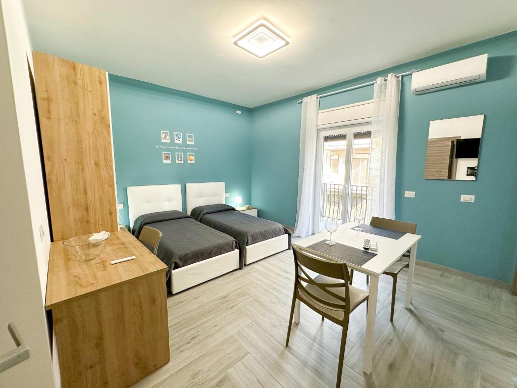 a room with a bed and a table and a desk at Ferrera Suite & Rooms in Misterbianco