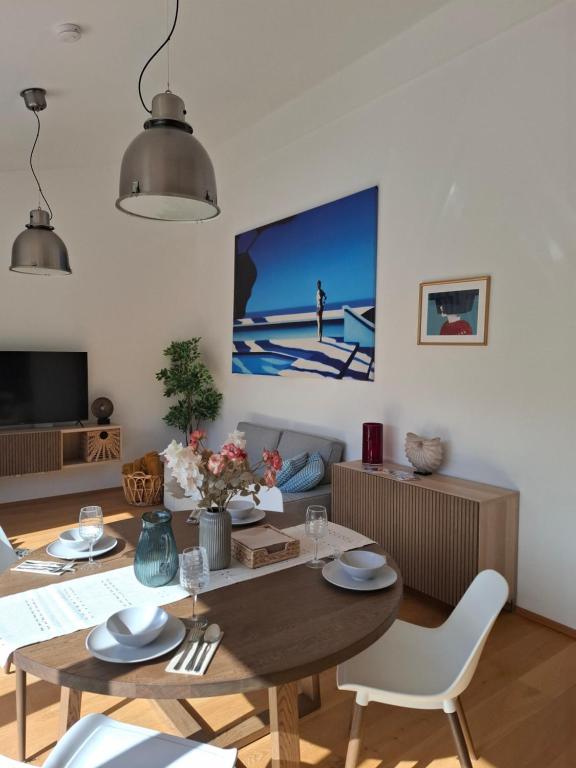 a living room with a table and chairs and a tv at Penthouse mit Seeblick & Terrasse Top 7 in Reifnitz