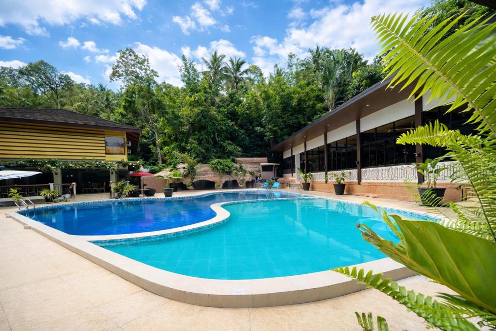 a swimming pool in front of a building at Kamayan sa Palaisdaan Hotel and Resort Quezon in Lucban