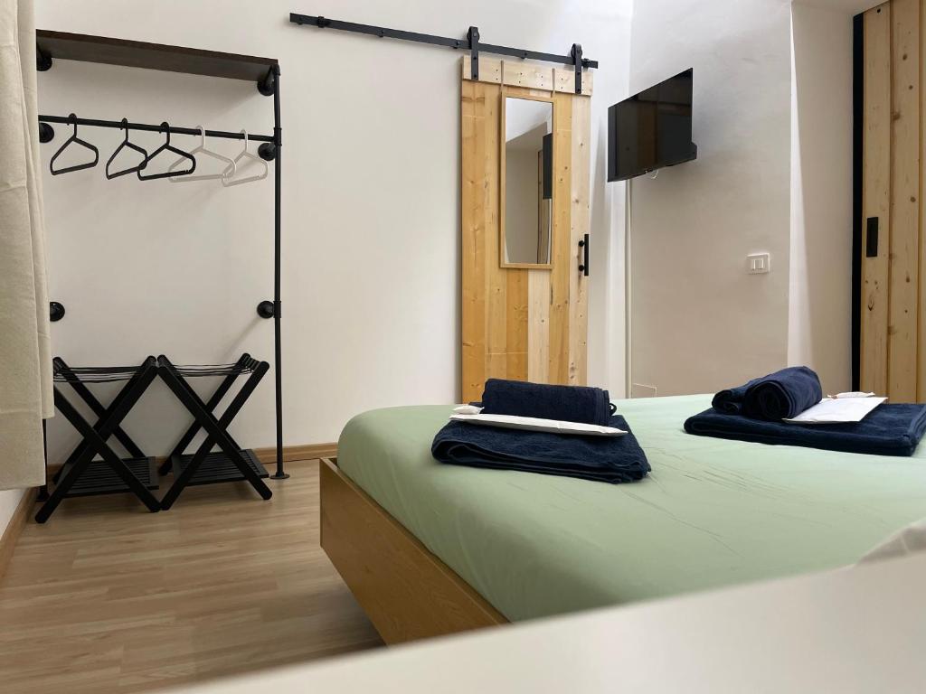 a bedroom with a bed with blue towels on it at La Maison De Rennì in Viterbo
