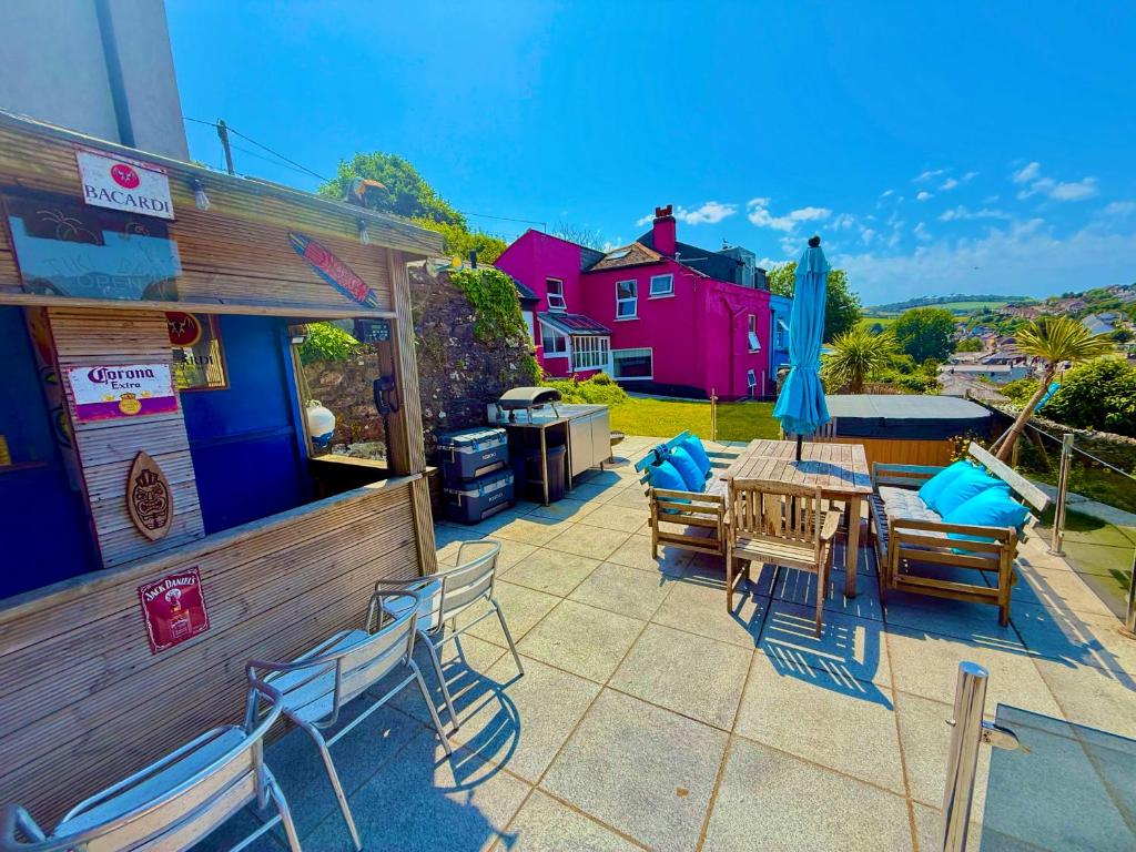 a patio with a table and chairs and a bar at High Cross House in Millbrook