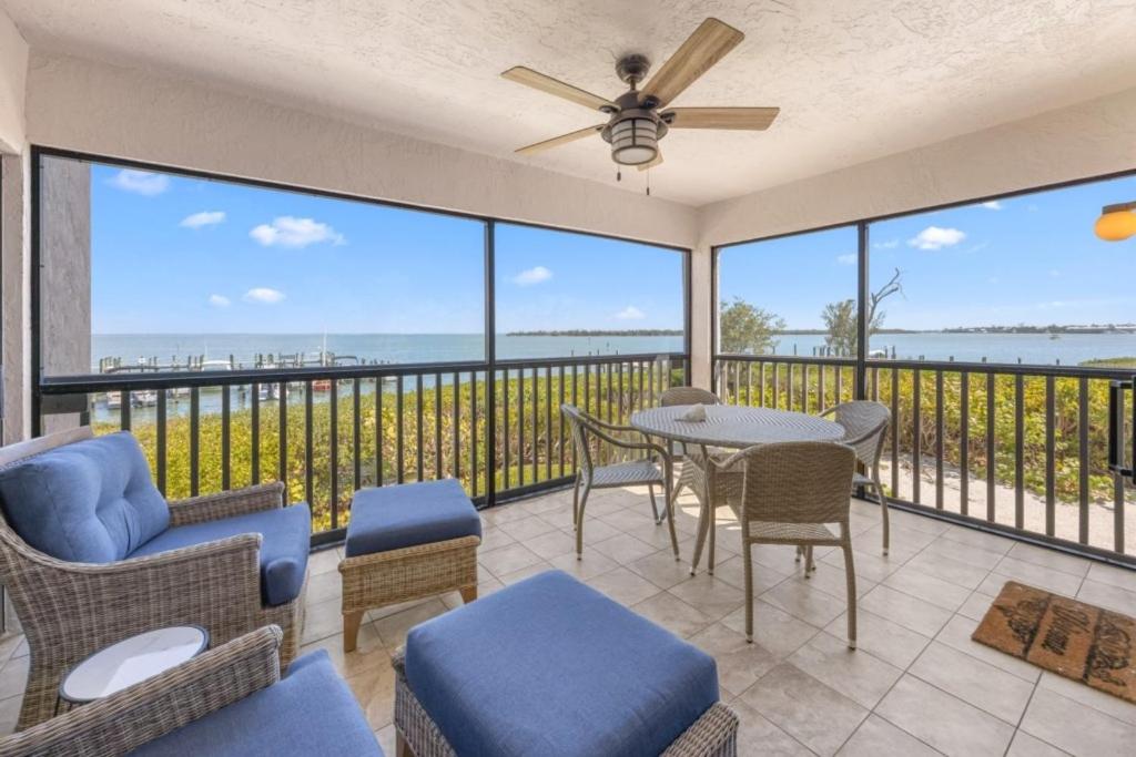 a living room with a balcony with a table and chairs at Sunset Captiva Bayside Unit 103 condo in Captiva