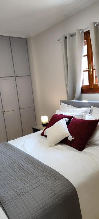 a bedroom with a bed with red and white pillows at A&Bpikermistudios2 in Pikérmion