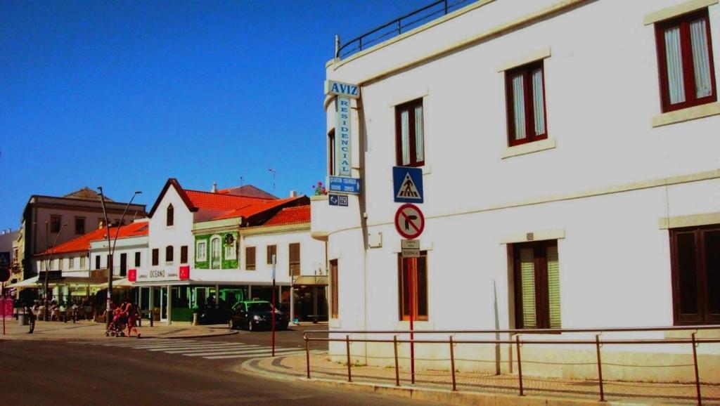 a city street with a white building with a no parking sign at Residência Aviz in Peniche