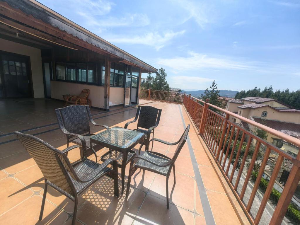 a patio with chairs and a table on a balcony at Xiannv Mountain House in Chongming