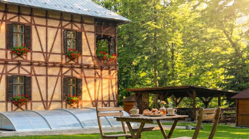a table and chairs in front of a house at Penzión Astoria - bazén a oddych na Liptove in ľubochňa