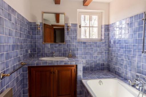 a blue tiled bathroom with a tub and a sink at Chambre bleue Villalormarin in Saint-Tropez