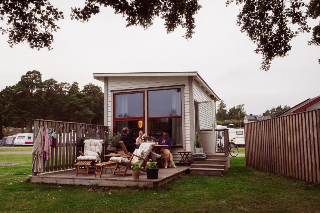 two people sitting on the porch of a tiny house at Nävekvarns Skärgårdscamping in Nävekvarn
