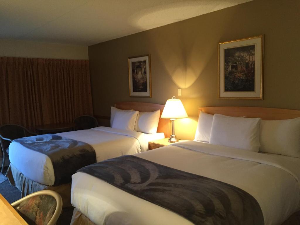 una habitación de hotel con 2 camas y una lámpara en Eastglen Inn, en Edmonton