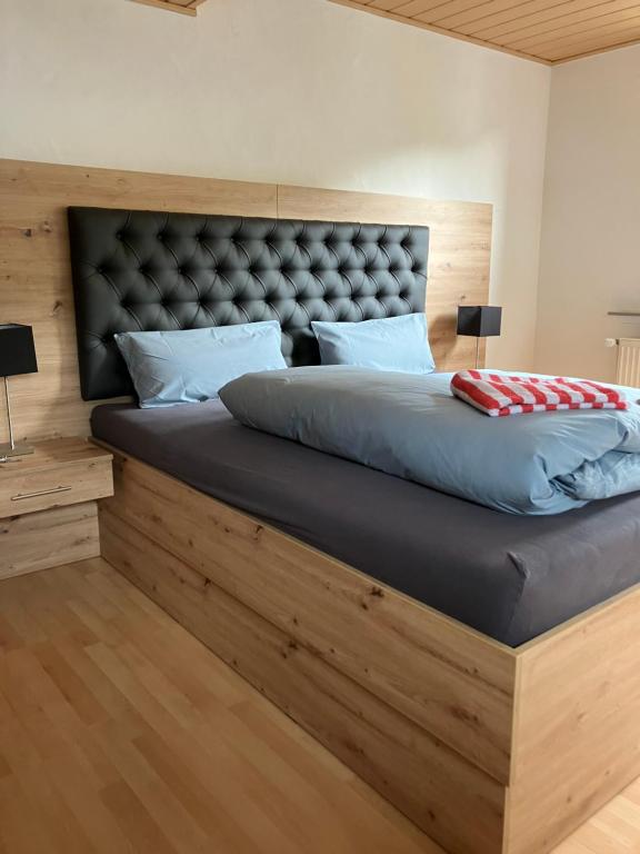 a bedroom with a large bed with a large headboard at Linnenkerlstube in Willingen